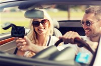 photo of happy man and woman driving car and using gps navigation system