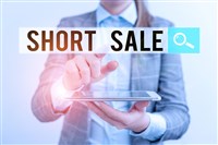 Short sale words floating above a tablet with a businessman in the background