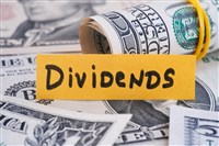 The word Dividends and dollar bills. Close up.