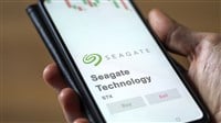 Photo of someone holding a smartphone with the Seagate logo and Buy Sell buttons below it. Seagate issues warns that cloud solutions demand is surging.