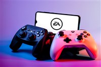 Photo of video game controllers and a smartphone showing the Electronic Arts logo. EA Q2 earnings engages players and builds value.