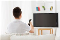 Photo of a person sitting in front of a TV. DoubleVerify makes sure ads are seen by real people.