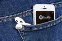 iPhone with Spotify App and headphones in back pocket of jeans
