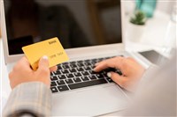 Businesswoman enters her payment information into an online portal.