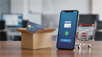 Smartphone displaying a digital wallet sign-up screen beside a cardboard shipping box with a credit card inside and a small shopping cart, symbolizing e-commerce and online payments growth.