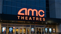 AMC Theatres entrance with glowing red logo at dusk, reflecting renewed box office surge and strong cinema demand.