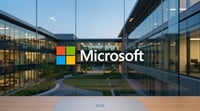 Microsoft logo displayed on glass overlooking a modern corporate campus courtyard.