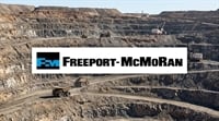 Freeport-McMoRan logo overlaid on an aerial view of an open-pit copper mine with haul trucks.