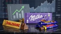 Toblerone, Milka, and Cadbury chocolate bars arranged beside a rising bar chart graphic with gold coins.