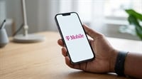 A hand holds a smartphone displaying the T-Mobile logo on a white screen.