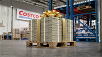 A large pallet stacked with bundled cash and topped with a gold bow inside a Costco Wholesale warehouse.