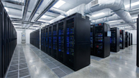 Rows of black server racks with blue indicator lights fill a commercial data center facility.