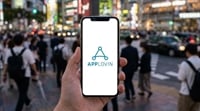 A hand holds a smartphone displaying the AppLovin logo on a busy urban street crossing.