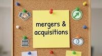 A yellow sticky note reading "mergers and acquisitions" pinned to a corkboard with colorful pushpins and financial icons.
