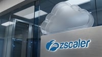 Zscaler logo and cloud icon displayed on a brushed metal sign outside a modern office building.