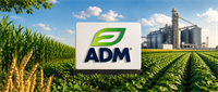 ADM company logo sign displayed in a crop field with grain storage silos and processing facility in the background.
