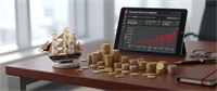 Model ship and stacked coins beside a tablet showing a Vanguard VTSAX portfolio summary and growth chart on a desk.
