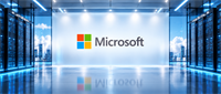 Microsoft logo displayed on a wall between rows of illuminated server racks in a data center.