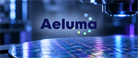 Aeluma logo displayed over a semiconductor wafer on a fabrication tool, representing a chipmaking company.