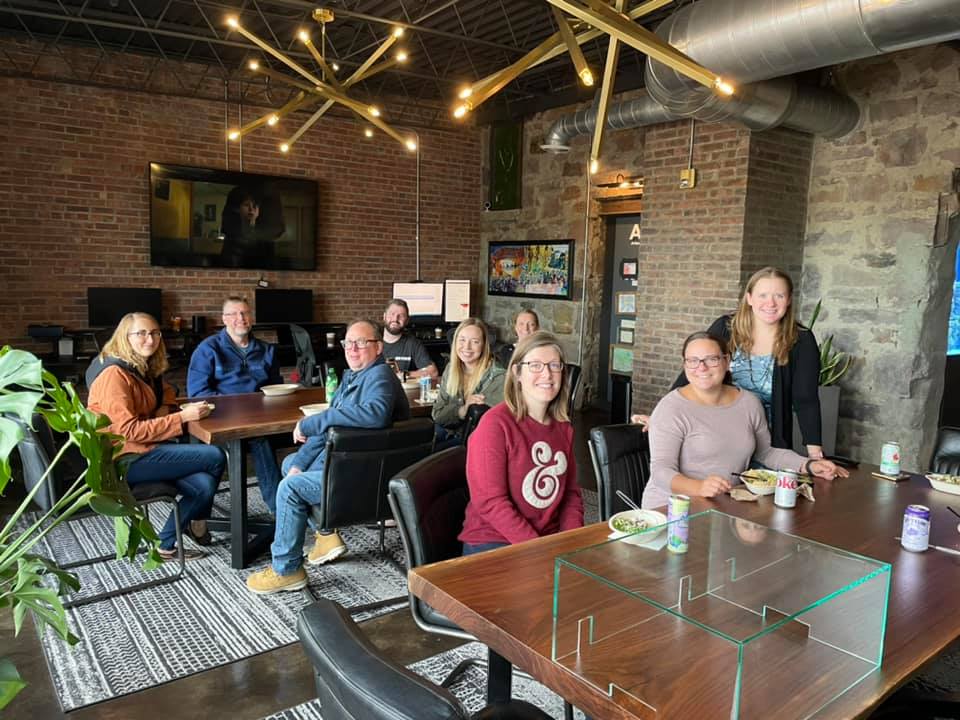 MarketBeat employees sitting around the lunch table in the office.