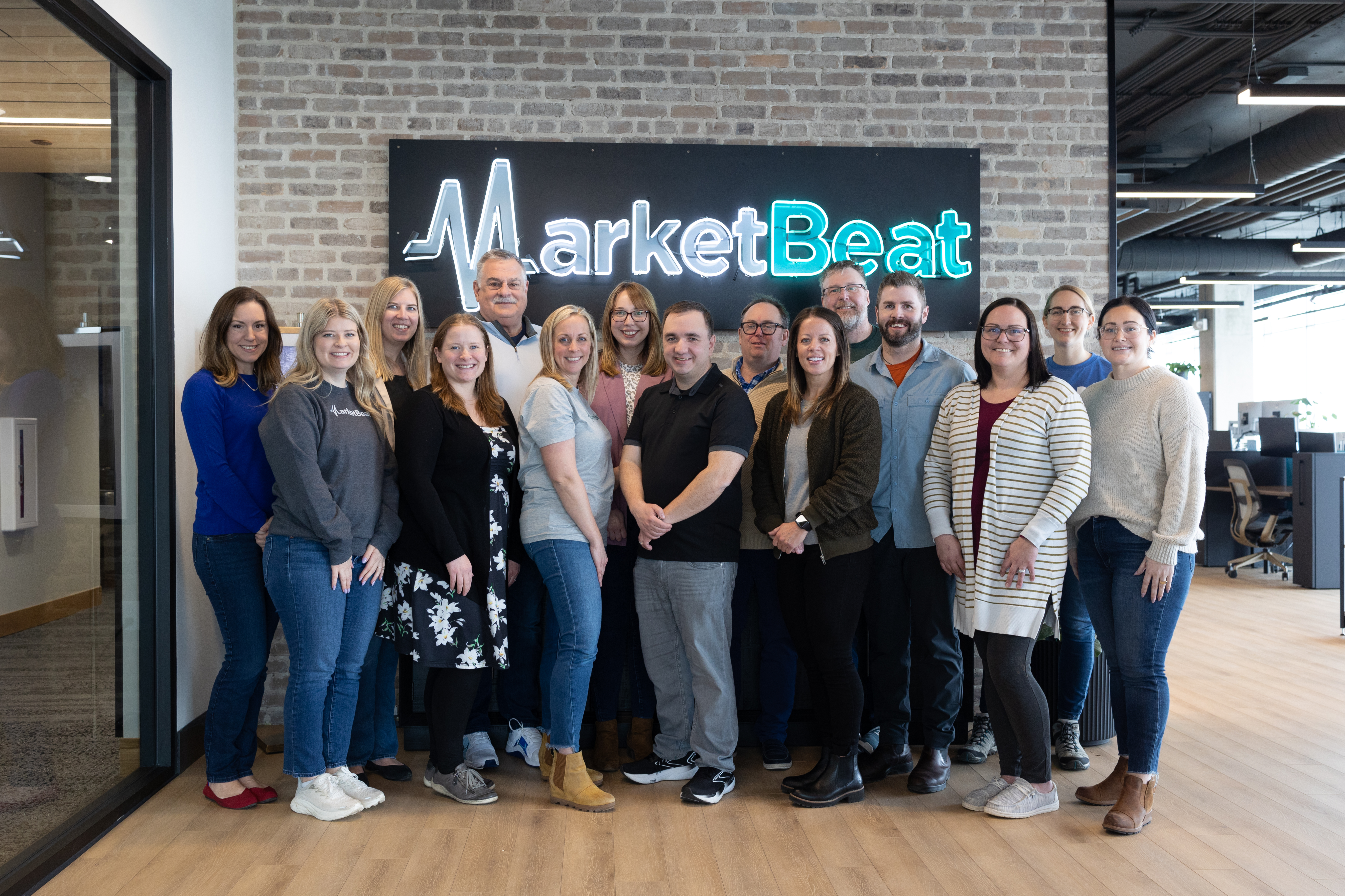 Picture of the MarketBeat team in front of MarketBeat sign.