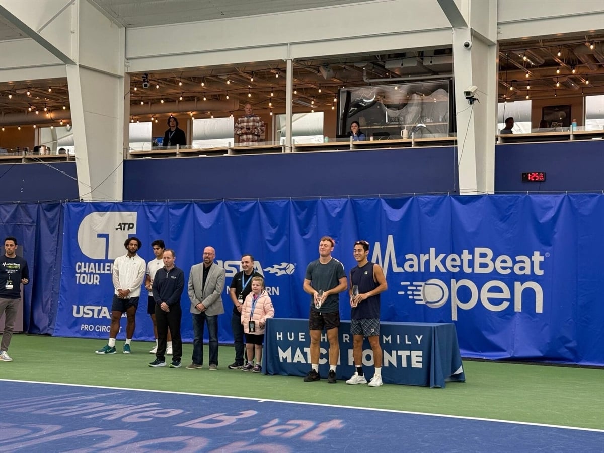 Matt Paulson poses for photographs after handing out MarketBeat Open 2025 trophies to doubles champions Rinky Hijikata and Mac Kiger.