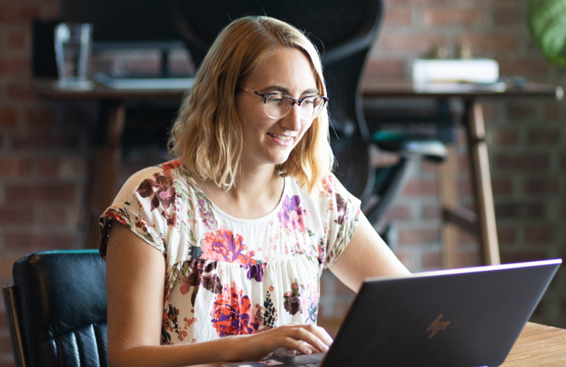 Rebecca McKeever sits at a table working on her laptop.