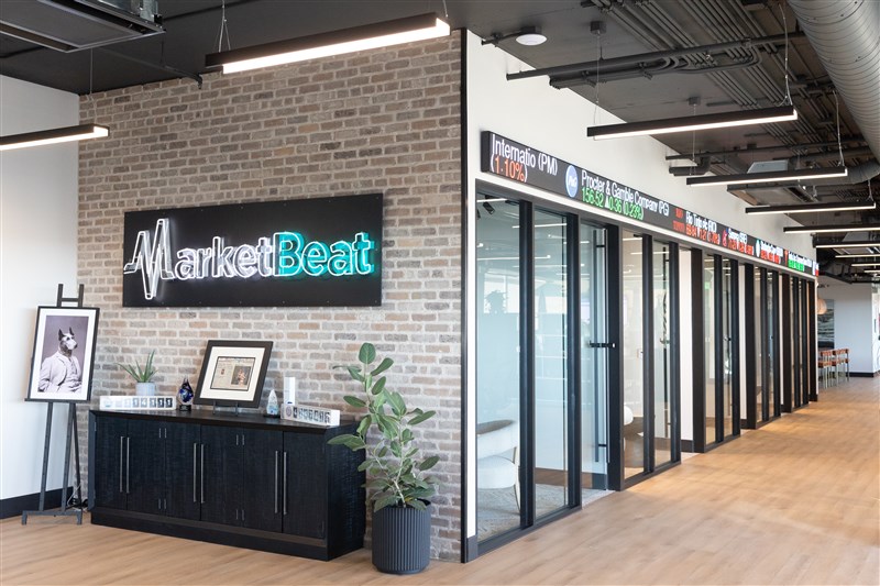 Picture of MarketBeat's office featuring a digital stock market ticker sign.