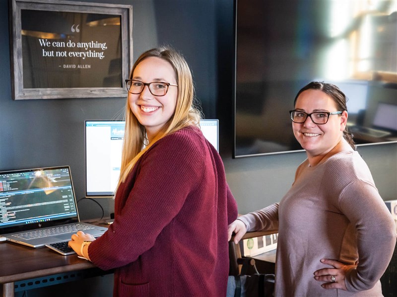 Staff working together at laptop station